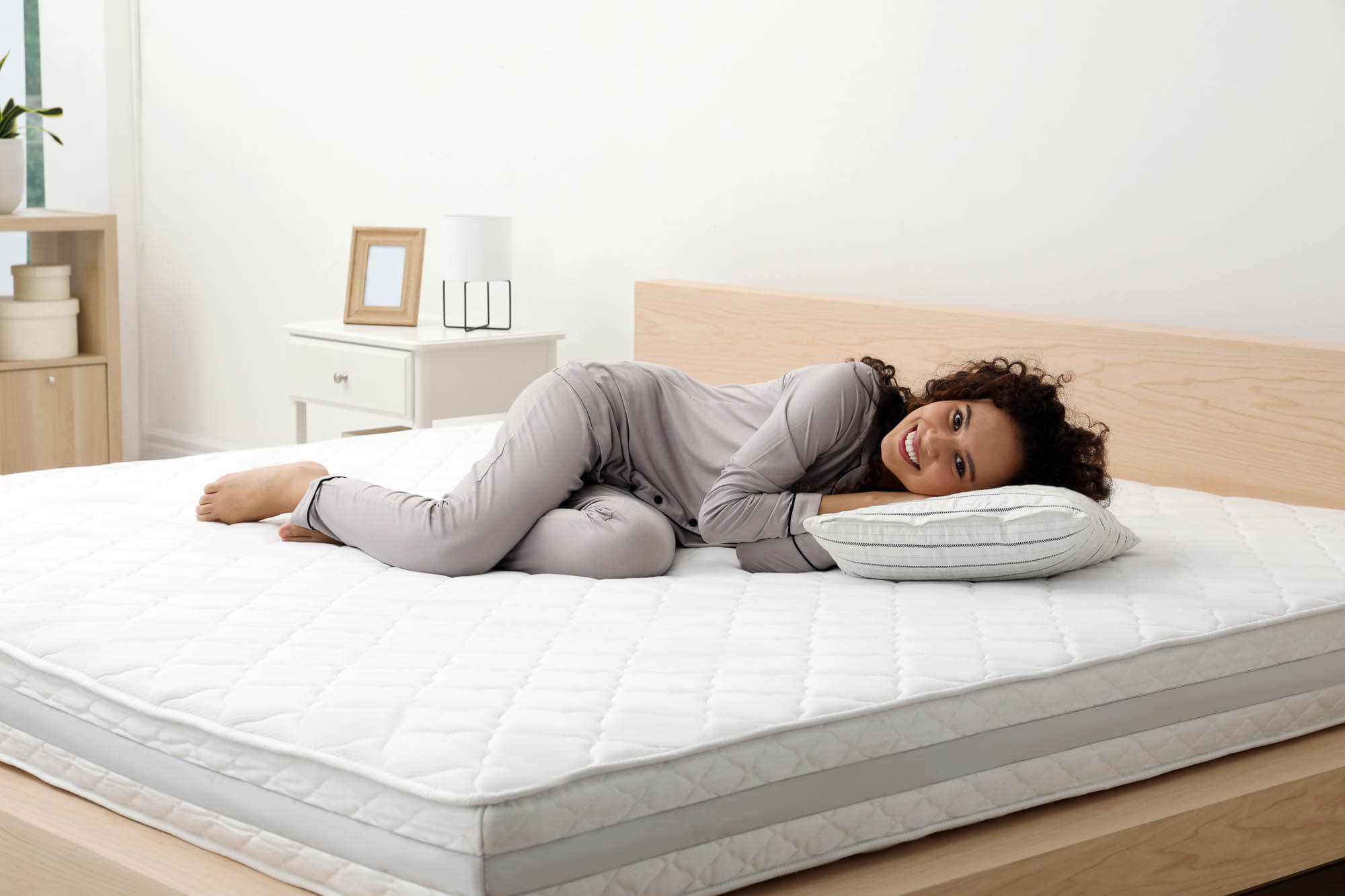 Woman comfortably resting on a mattress with a pillow